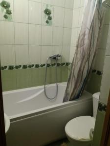 a bathroom with a tub and a toilet and a shower at Sunrise in Rēzekne