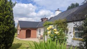 una casa blanca con techo negro y patio en Lough Shore Cottage, en Magherafelt