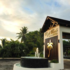 eine Statue vor einem Gebäude mit einem Schild in der Unterkunft Royal Beach Hôtel in Ambatoloaka