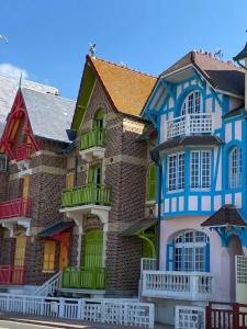 een rij huizen geschilderd in verschillende kleuren bij Villa les Fleurs Appartement en front de mer in Mers-les-Bains