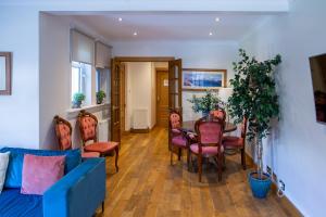 a living room with a blue couch and a table and chairs at Luss Cottages at Glenview in Luss