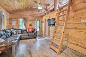 un soggiorno con un divano in pelle e una TV di Charming Houghton Lake Cottage with Backyard! a Houghton Lake