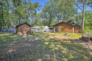 una baita e un capanno in un cortile di Charming Houghton Lake Cottage with Backyard! a Houghton Lake