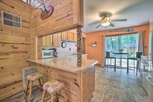 una cucina con pareti in legno e bancone con sgabelli di Charming Houghton Lake Cottage with Backyard! a Houghton Lake Altre 17 foto