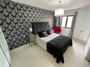 a bedroom with a bed and a black and white wall at Sun club playa del águila by la piedra viva in San Bartolomé de Tirajana +22 photos