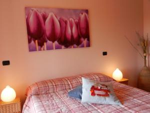 1 dormitorio con 1 cama con una pintura en la pared en Casa Luciana, en Mergozzo