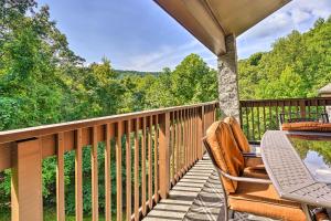 a balcony with a table and chairs and a view of the woods at Cozy Gatlinburg Condo about 2 Mi to National Park! in Gatlinburg