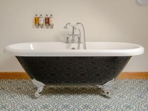 a bath tub sitting on a floor in a bathroom at Hares Furrow - Uk12607 in Burton Overy