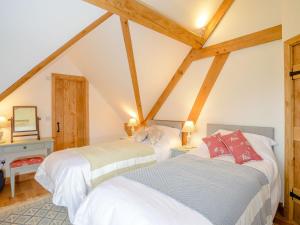 2 Betten in einem Dachzimmer mit Holzbalken in der Unterkunft Hares Furrow - Uk12607 in Burton Overy