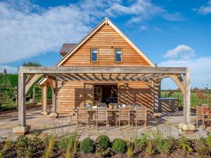 a wooden pavilion with a table and chairs in front of a house at Hares Furrow - Uk12607 in Burton Overy