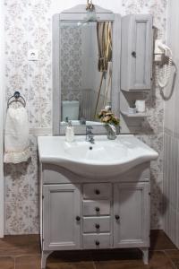 ein Badezimmer mit einem weißen Waschbecken und einem Spiegel in der Unterkunft Hauptman apartman in Nagyatád