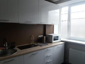 a kitchen with a sink and a microwave on a counter at Sunbeam in Rēzekne