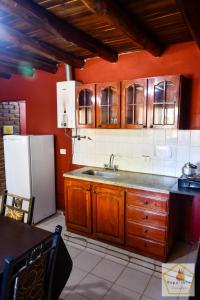 a kitchen with a sink and a refrigerator at Cabañas Uspallata in Uspallata