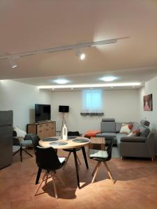 a living room with a table and chairs and a couch at Sakura Apartment in Mosonmagyaróvár