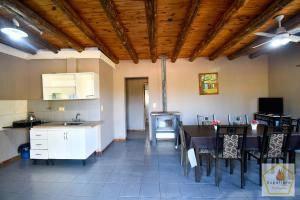 Cabañas Uspallata في أوسبالاتا: مطبخ وغرفة طعام مع طاولة وكراسي