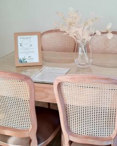 a wooden table with two chairs and a vase with flowers at El Patio Grande 