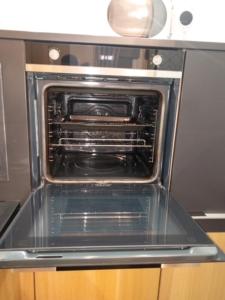 an oven with its door open in a kitchen at Stunning apartment on Perth Rd-mins from City Centre Dundee in Dundee