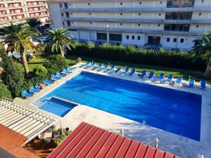 una vista aérea de una piscina con sillas y un edificio en Payet Apartments, en L'Estartit