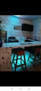 una cocina con barra y dos taburetes. en APARTA- Refugio El Retiro verde, en Leticia