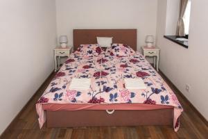 ein Bett in einem Schlafzimmer mit zwei Nachttischen in der Unterkunft Hauptman apartman in Nagyatád