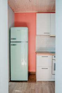einen weißen Kühlschrank in einer Küche mit orangefarbener Wand in der Unterkunft Με θέα το ηλιοβασιλεμα 2 in Áfissos