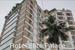 ComillaにあるHotel Elite Palaceのヤシの木が前に生えている高い建物