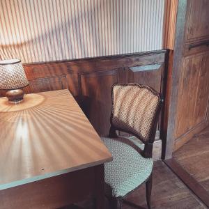 a chair sitting next to a wooden table with a lamp at Parc de Lesseps in Meunet-Planches