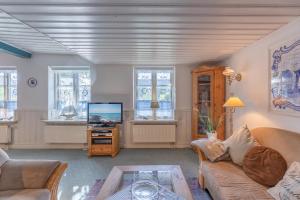 a living room with a couch and a tv at Reetkate Oldersbek in Oldersbek