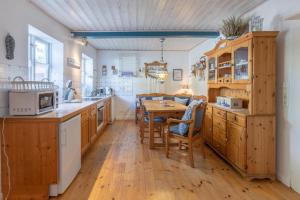 a kitchen with wooden cabinets and a wooden table at Reetkate Oldersbek in Oldersbek