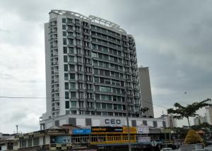 um edifício branco alto com muitas janelas em Wifi 100Mbps+Netflix - Wau Bulan Flies @ The CEO em Bayan Lepas