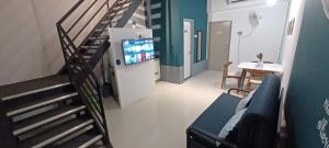 een woonkamer met een trap en een televisie bij Wifi 100Mbps+Netflix - Wau Bulan Flies @ The CEO in Bayan Lepas