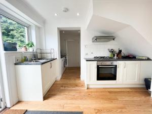 a kitchen with white cabinets and a sink at Home away from home Milngavie in Milngavie