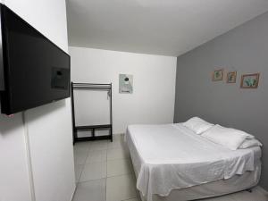 - une chambre avec un lit et une télévision à écran plat dans l'établissement Hotel Estadio Exprés, à Leticia