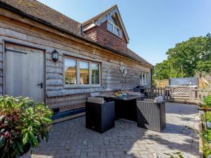 a wooden house with a patio with a table at The Barn in Coldwaltham