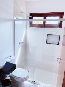 a white bathroom with a toilet and a shower at Pousada dos Poetas in Barra Grande +46 photos