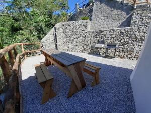 een houten bank naast een stenen muur bij Amalfi Coast - Mini Cottage vista mare con giardino in Vietri