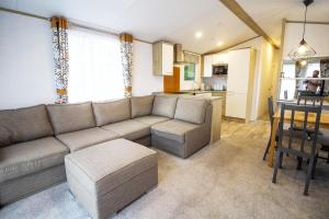 a living room with a couch and a table at Beautiful Caravan With Decking At Azure Seas In Suffolk, Sleeps 6 Ref 32004az in Lowestoft