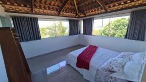 ein Schlafzimmer mit einem Bett und zwei Fenstern in der Unterkunft Tabatinga Relax Apartamentos in Conde