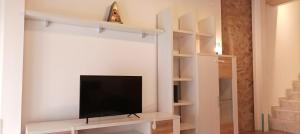 a living room with a tv on a white wall at Casa Bayer in Benicàssim