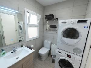a bathroom with a washing machine next to a toilet at Apartamento New Tarraco in Tarragona