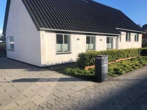 una casa con un bidone della spazzatura davanti di A-Bed a Esbjerg