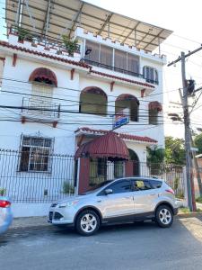um carro prateado estacionado em frente a um edifício em La gran Mansion em Santo Domingo