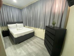 a small bedroom with a bed and a dresser at La gran Mansion in Santo Domingo
