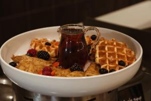 a bowl of cereal and waffles and a pitcher of syrup at Crowne Plaza Dublin Airport, an IHG Hotel in Santry
