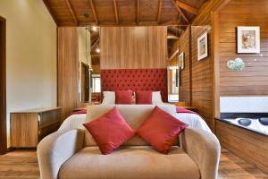 a bedroom with a bed with red pillows at Stillo Gramado Dutra in Gramado
