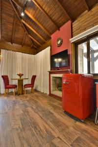 a living room with a red refrigerator and a table at Stillo Gramado Dutra in Gramado