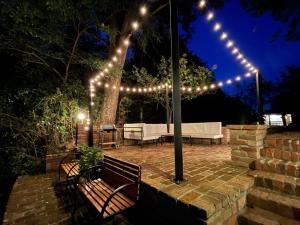a patio with benches and lights at night at Holiday home Casa Rio in Vinkovci