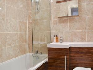a bathroom with a tub and a sink and a shower at Rose Cottage in Lofthouse