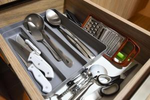 uma gaveta com tesouras e outros utensílios de cozinha em Stillo Gramado Aconchego em Gramado