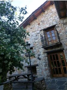 Almiruete的住宿－Las Peonías Casa Rural，一座石头建筑,设有窗户和街灯